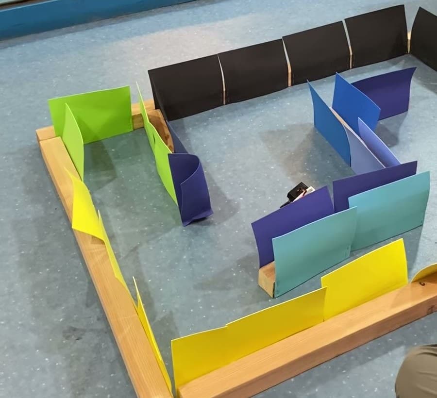 Wall-E robot navigating an overhead maze challenge